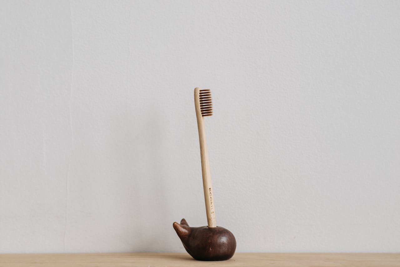 Wooden toothbrush displayed in a minimalist holder, promoting zero waste and dental hygiene.